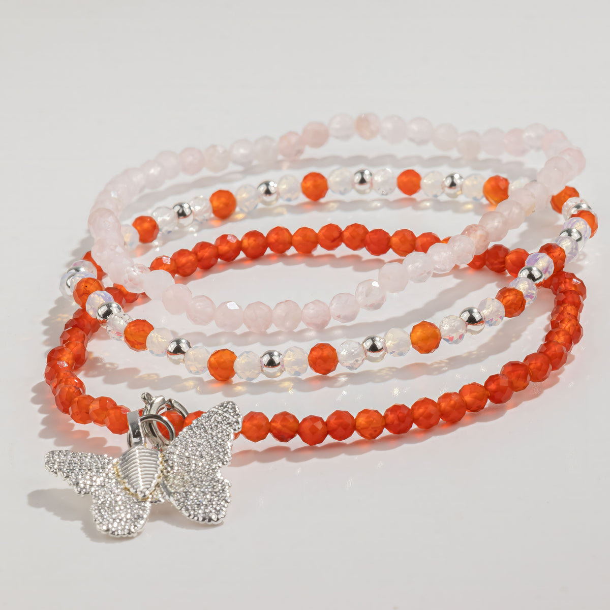 Three rose quartz and ruby bracelets arranged together
