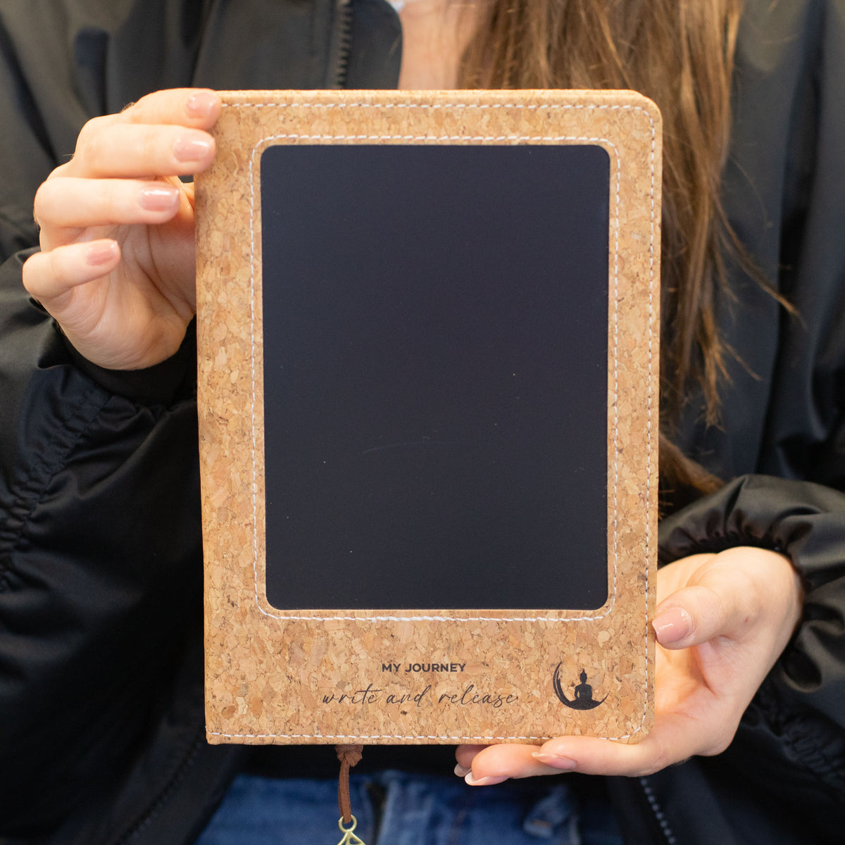 Notebook held upright to show the front cover and LCD screen
