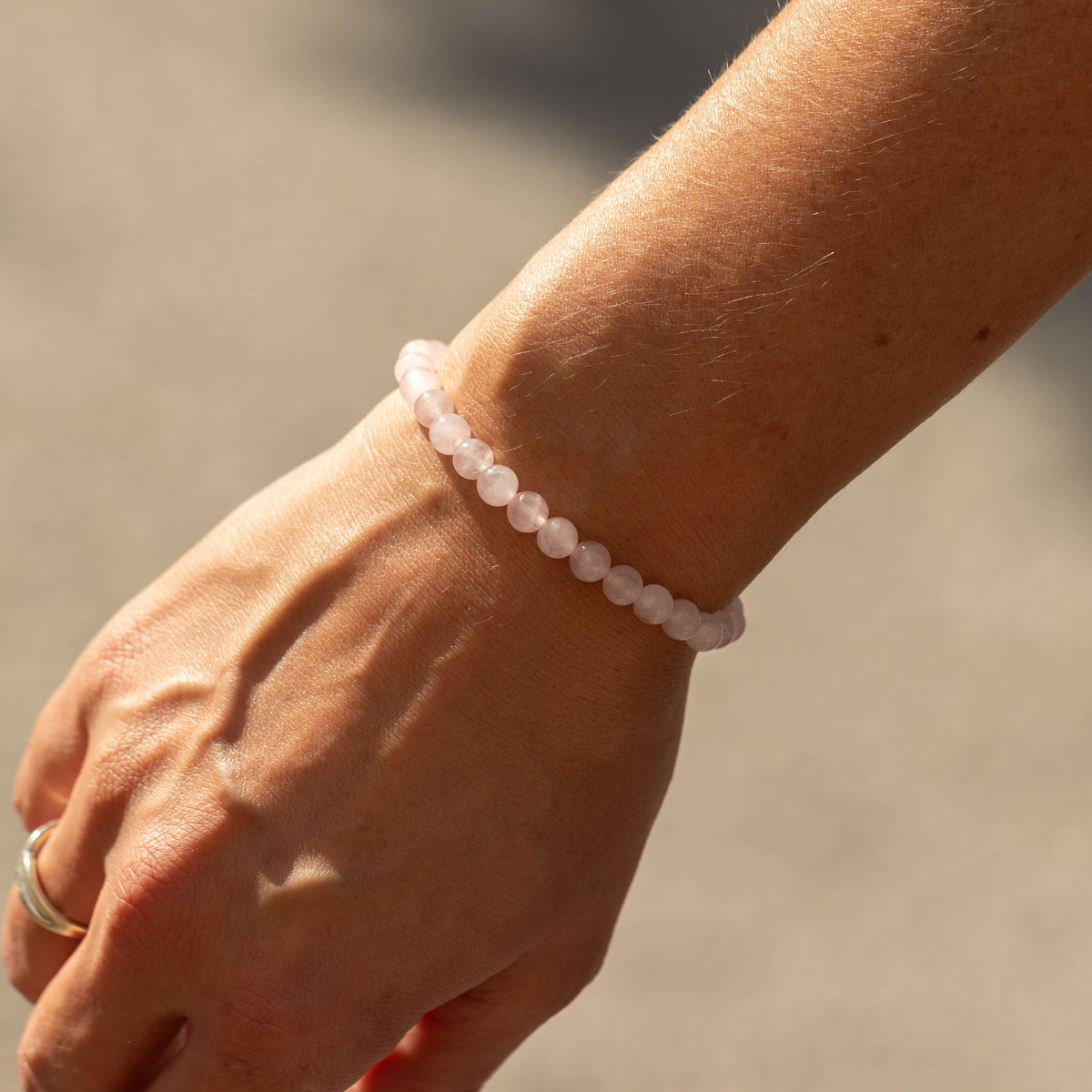 Rose quartz beads shown on a wrist from another angle