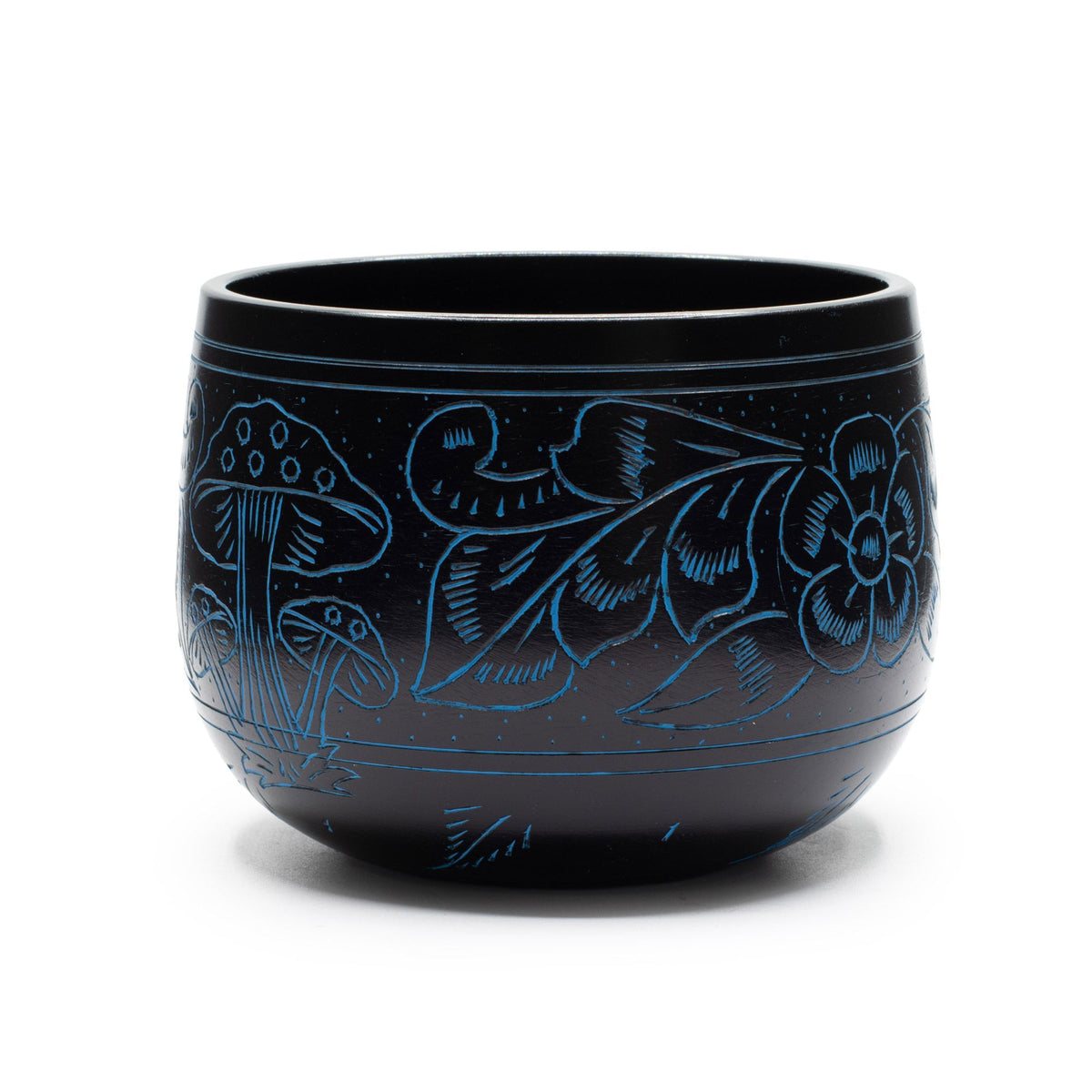 Blue singing bowl standing alone against a white background, with mushrooms and floral engraving