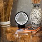 Lamp displayed on a wooden table beside a vase and notebook