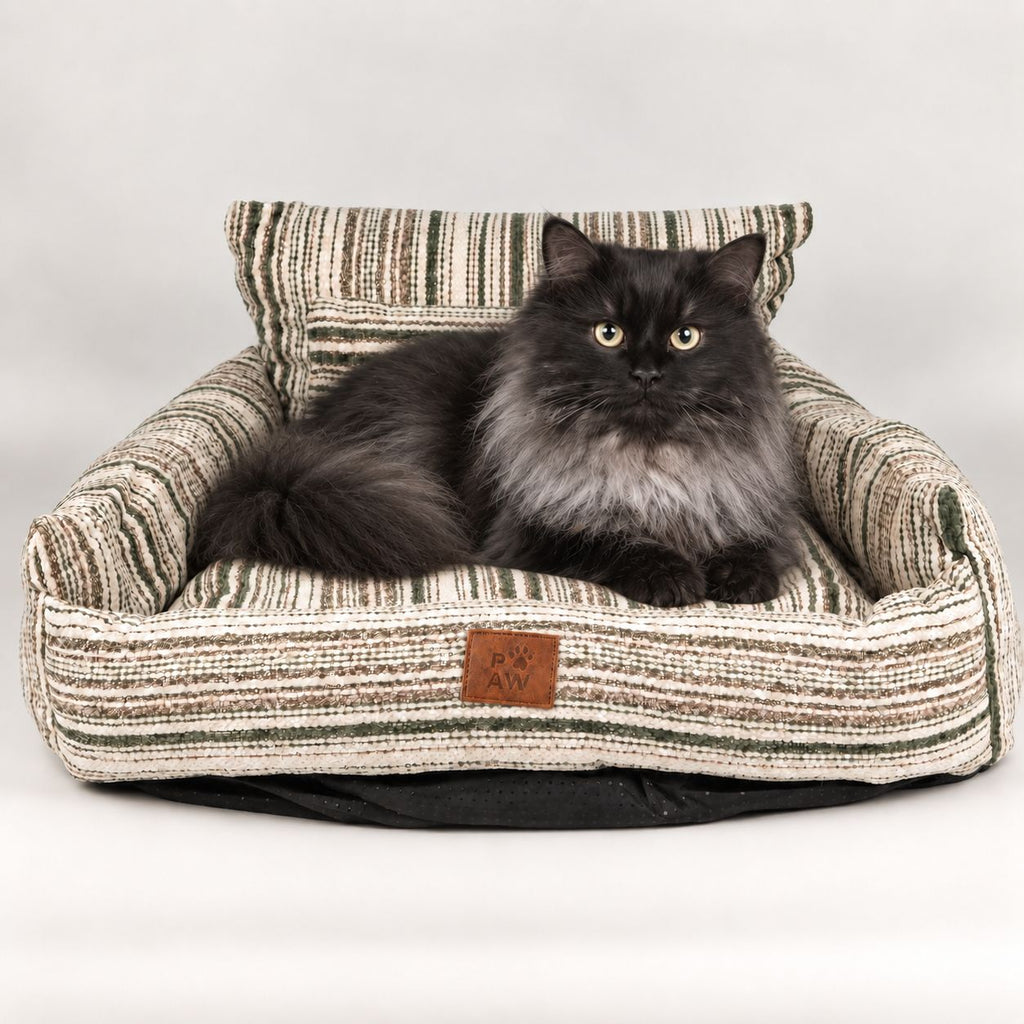 Long-haired cat resting in the striped sofa pet bed