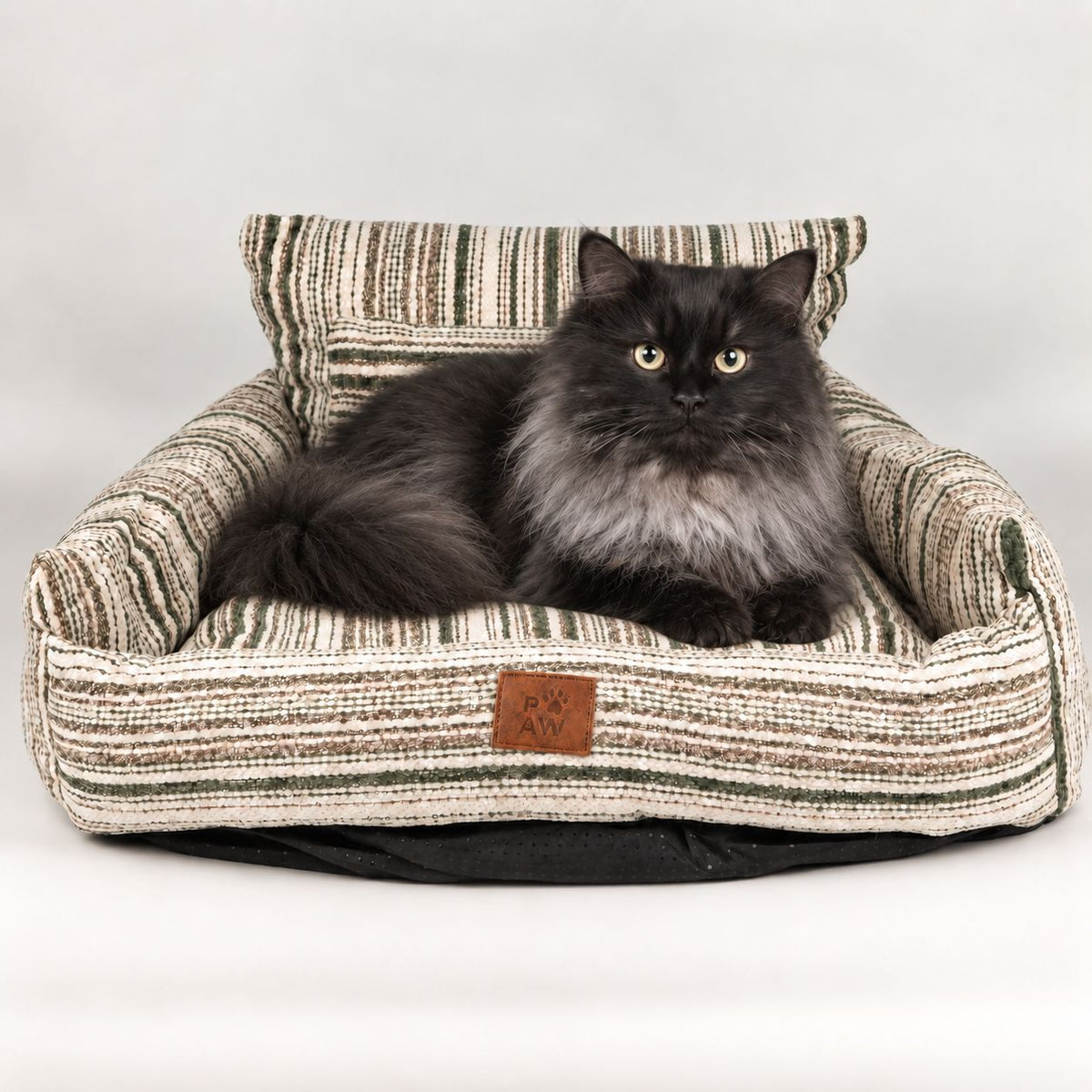 Long-haired cat resting in the striped sofa pet bed