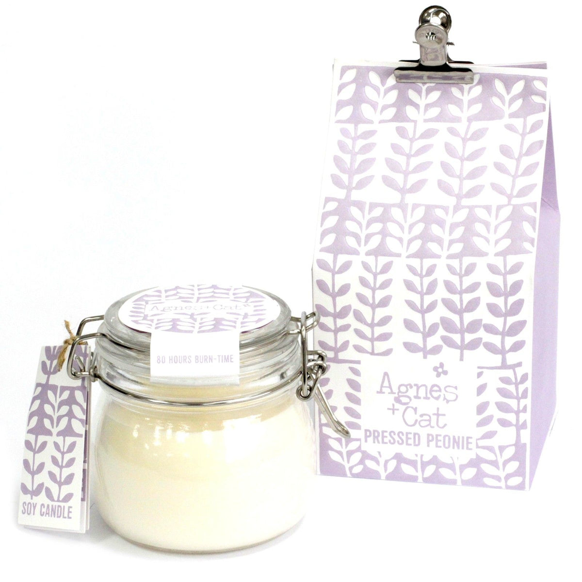 Agnes + Cat Kilner Jar Candle, Pressed Peonies, a cream candle in a clear glass jar beside its lilac patterned packaging