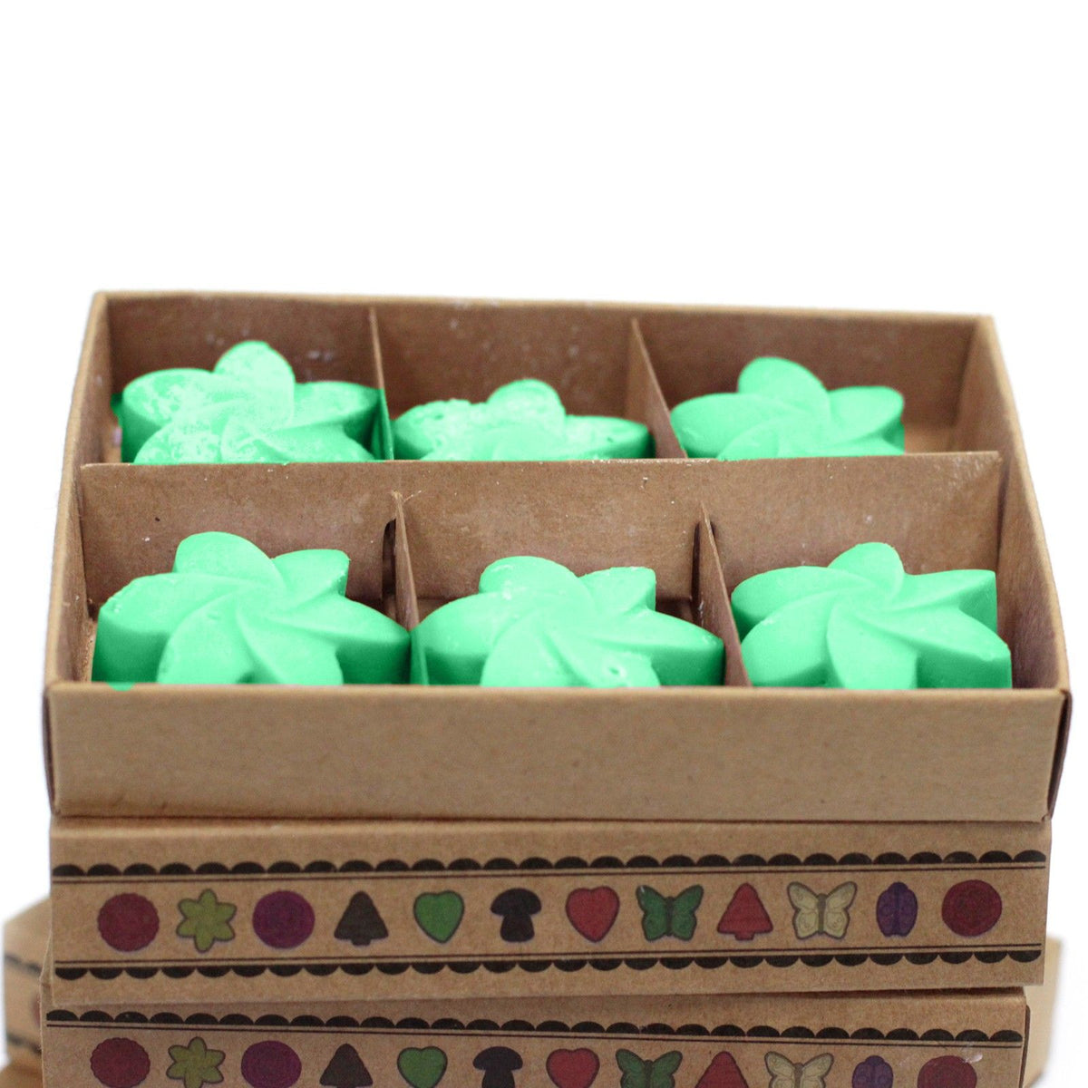Six green flower-shaped Hidden Garden wax melts shown in the divided open box, close-up front view