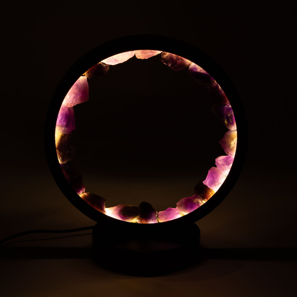 Amethyst stones glowing around the lamp's open centre in a dark setting
