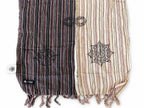 Close view of the scarf's striped panels, printed symbols and fringe
