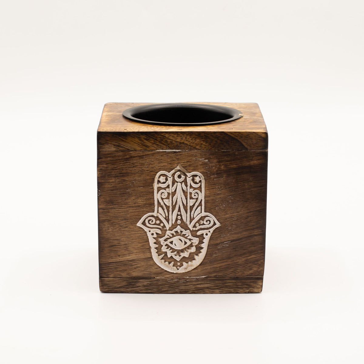 Hamsa oil burner viewed from the front, with a pale hand design on the brown wood and black dish
