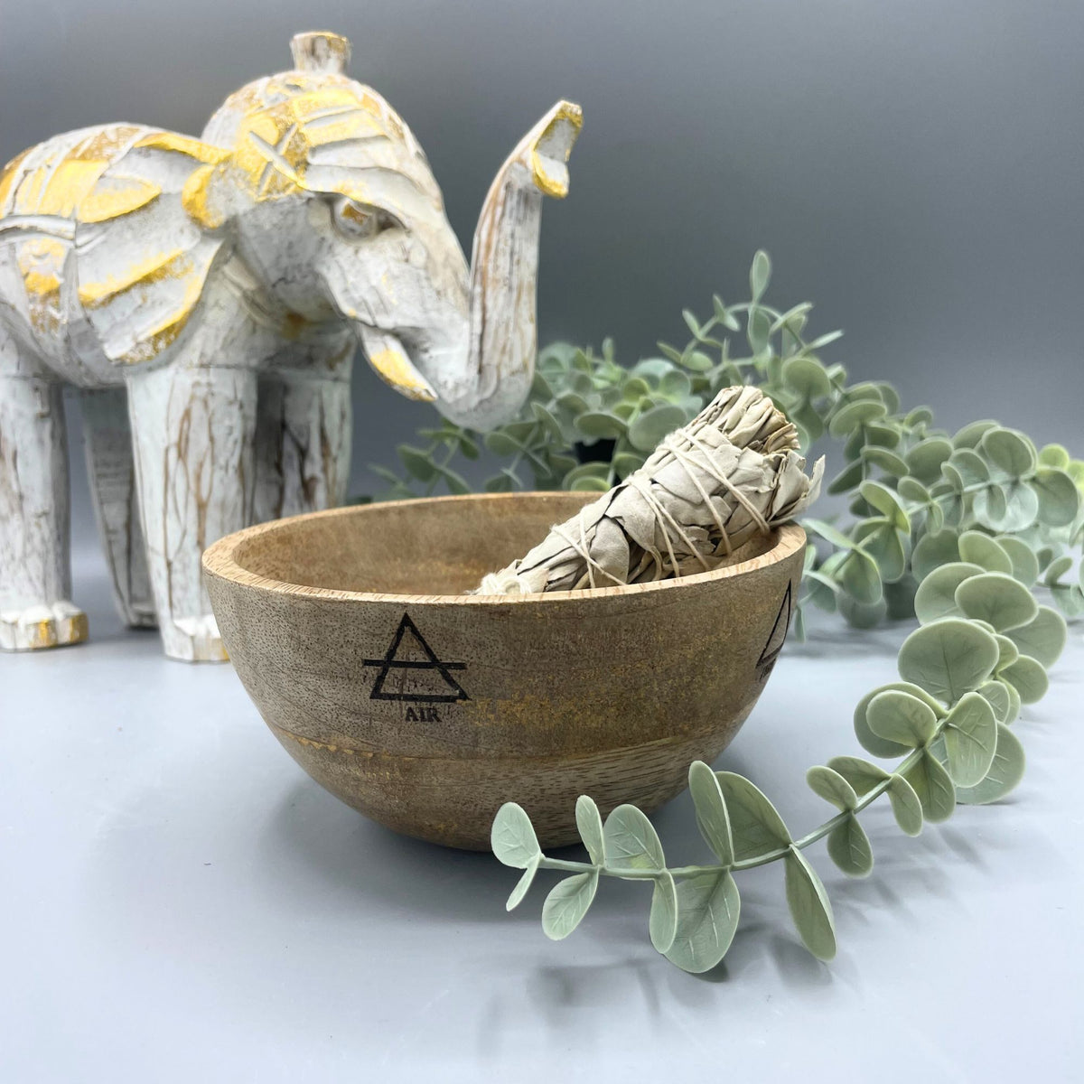 Wooden Smudge and Ritual Offerings Bowl, Four Elements, brown bowl with a tied herb bundle, greenery and an elephant ornament