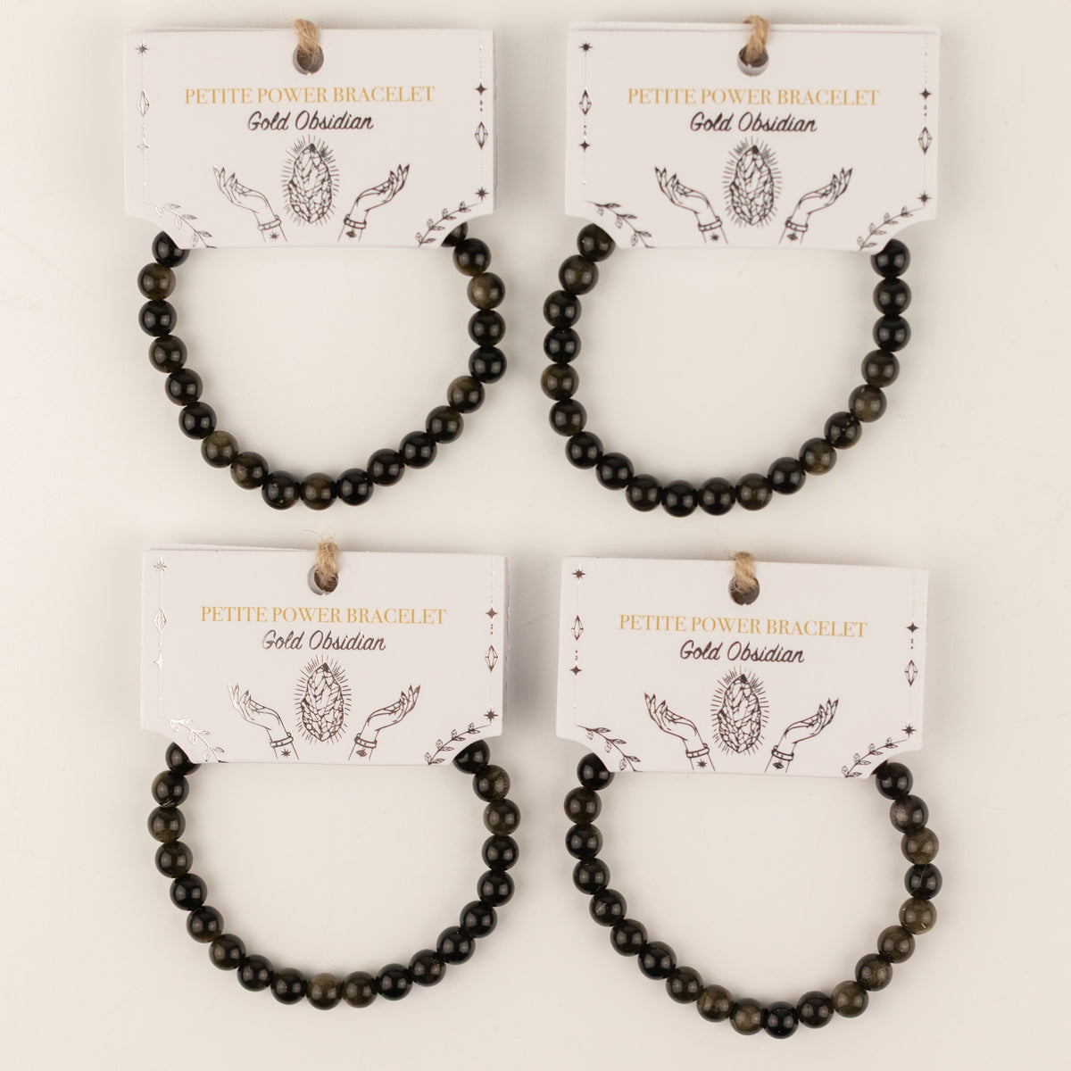 Four Gold Obsidian bracelets on illustrated presentation cards