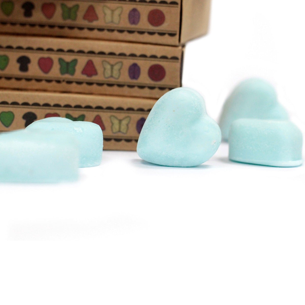 Box of 6 Wax Melts, Nagchampa, pale blue heart and rounded melts beside stacked patterned boxes