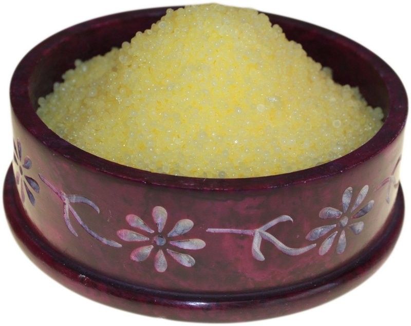 Citronella Simmering Granules, pale yellow grains heaped in a dark red patterned bowl, shown close up