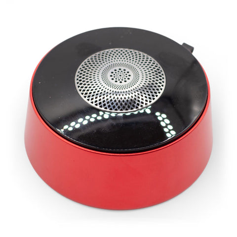 Close-up of the red speaker's black top, circular silver grille and white lights, on a white background