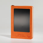 Orange notebook standing upright with its LCD screen blank
