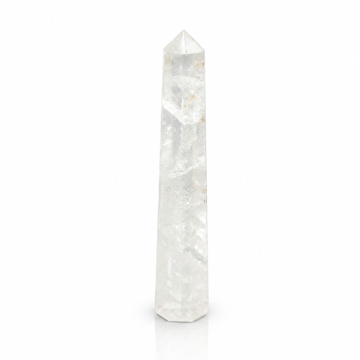 Single clear rock crystal obelisk point standing upright against a white background