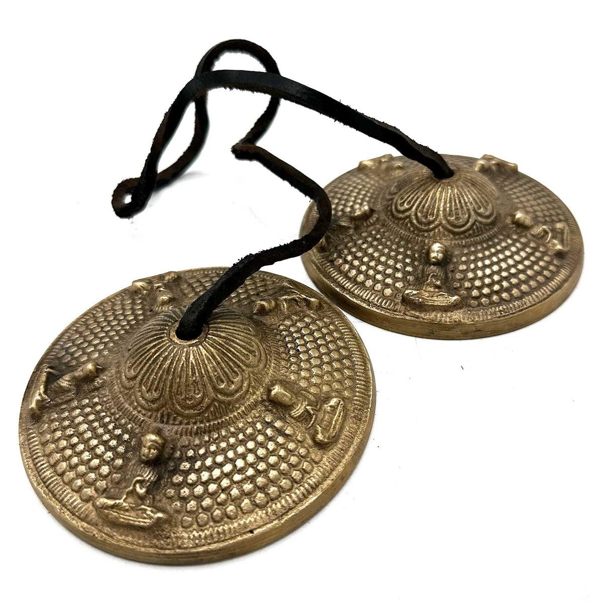 Five Buddha tingsha bells at an angle on white, showing their raised edges and black cord