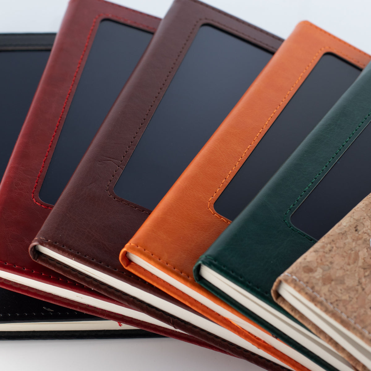 Close view of notebooks with orange, red, brown and green covers