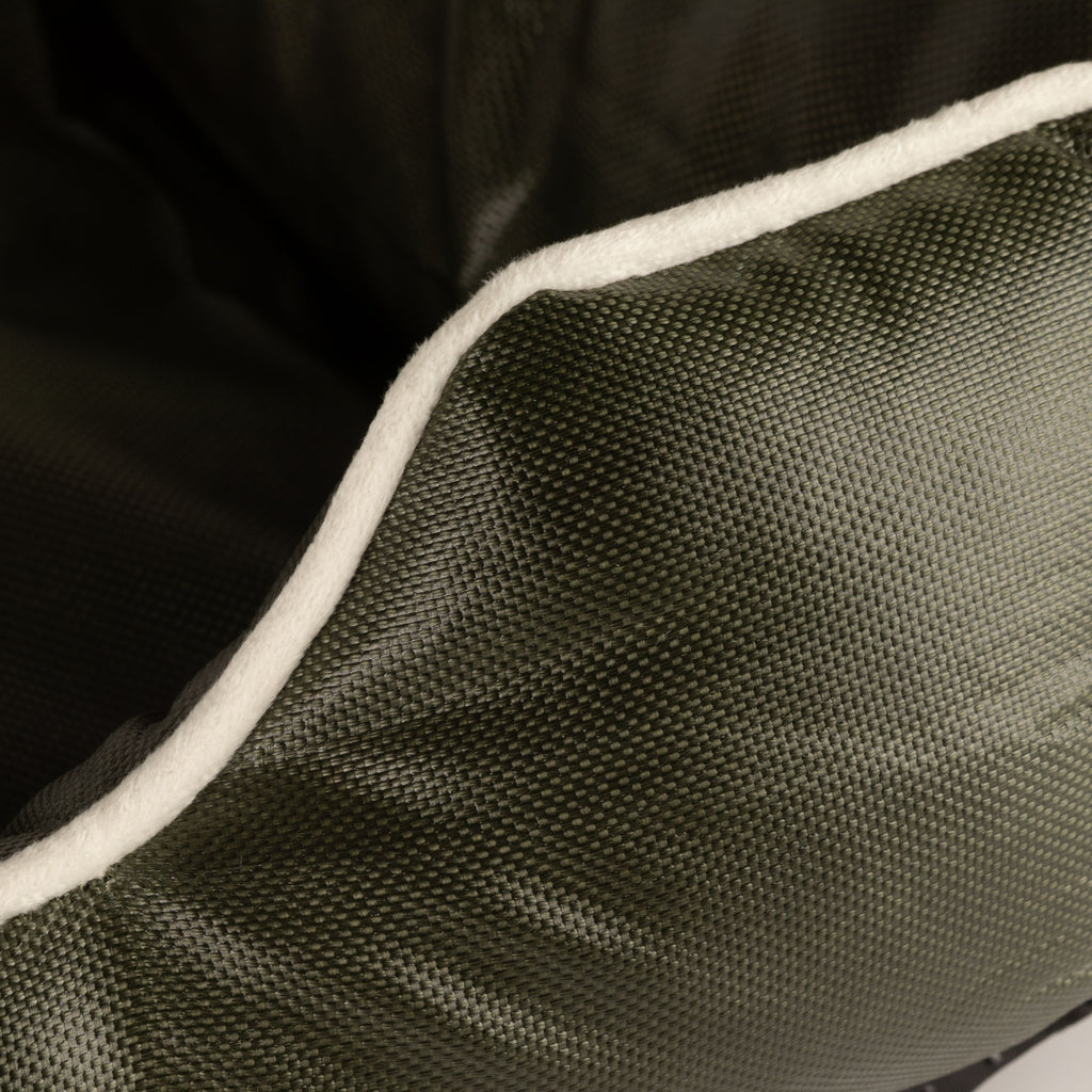 Close-up of cream piping on the khaki-green bed