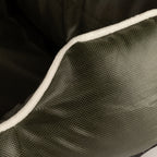 Close-up of cream piping on the khaki-green bed