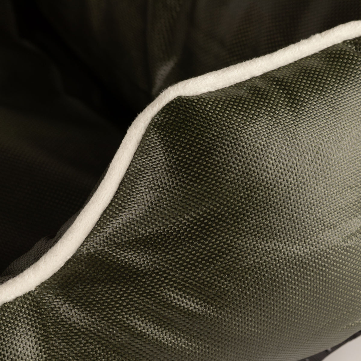 Close-up of cream piping on the khaki-green bed