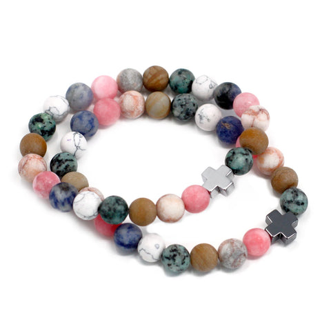 Pair of rainbow gemstone friendship bracelets arranged in overlapping circles on white