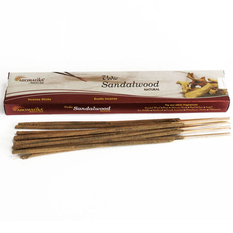Vedic Sandalwood incense sticks laid in front of a long cream and red box, viewed from above