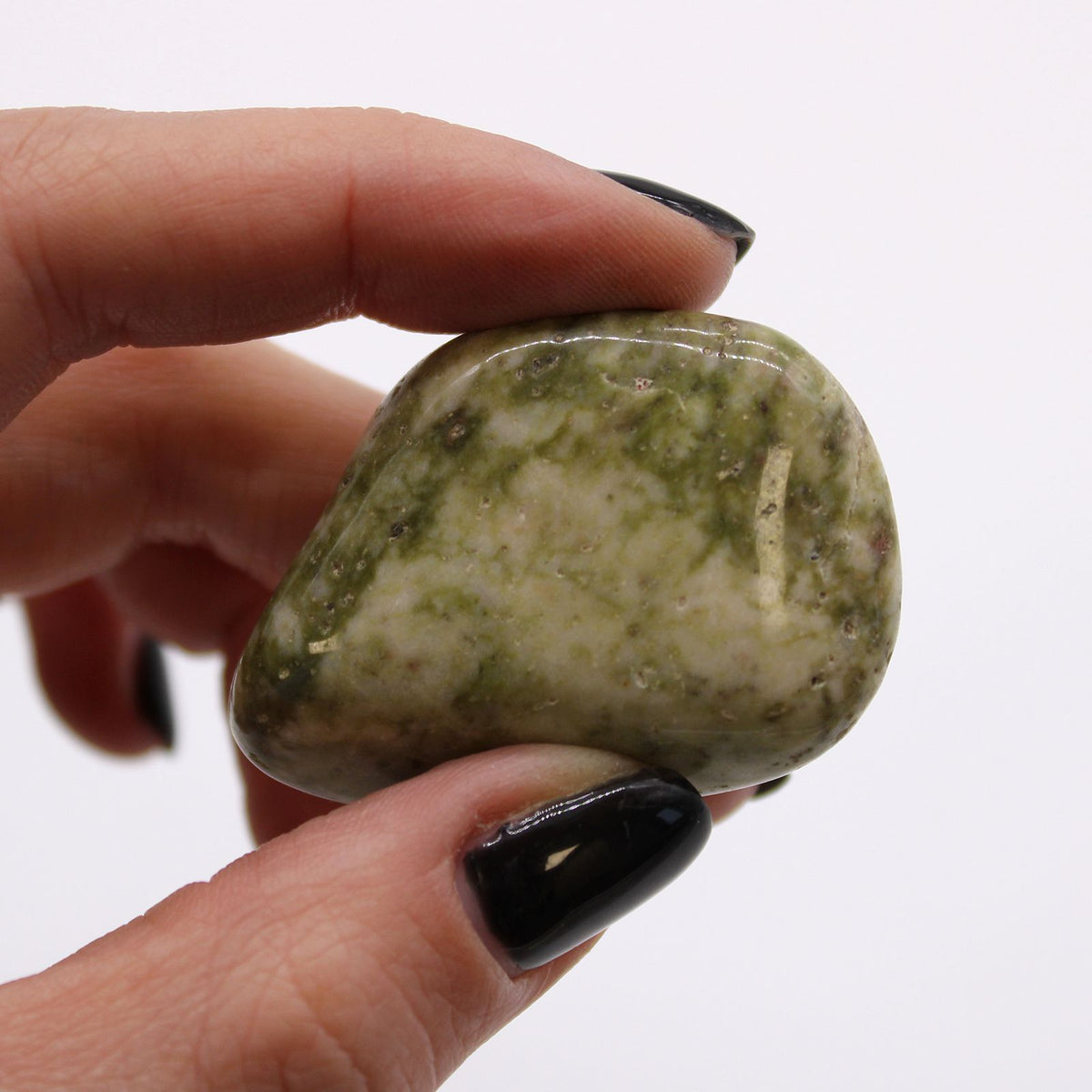 Large African Tumble Stones, Epidote Snowflake, a mottled green and cream polished stone held between fingers