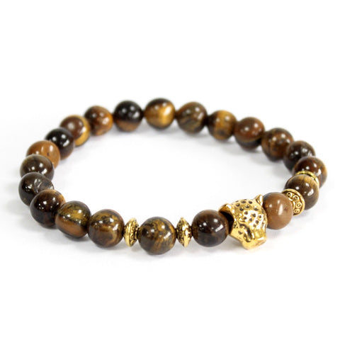 Tiger eye gemstone bracelet of brown and gold-toned beads with a gold leopard charm on white