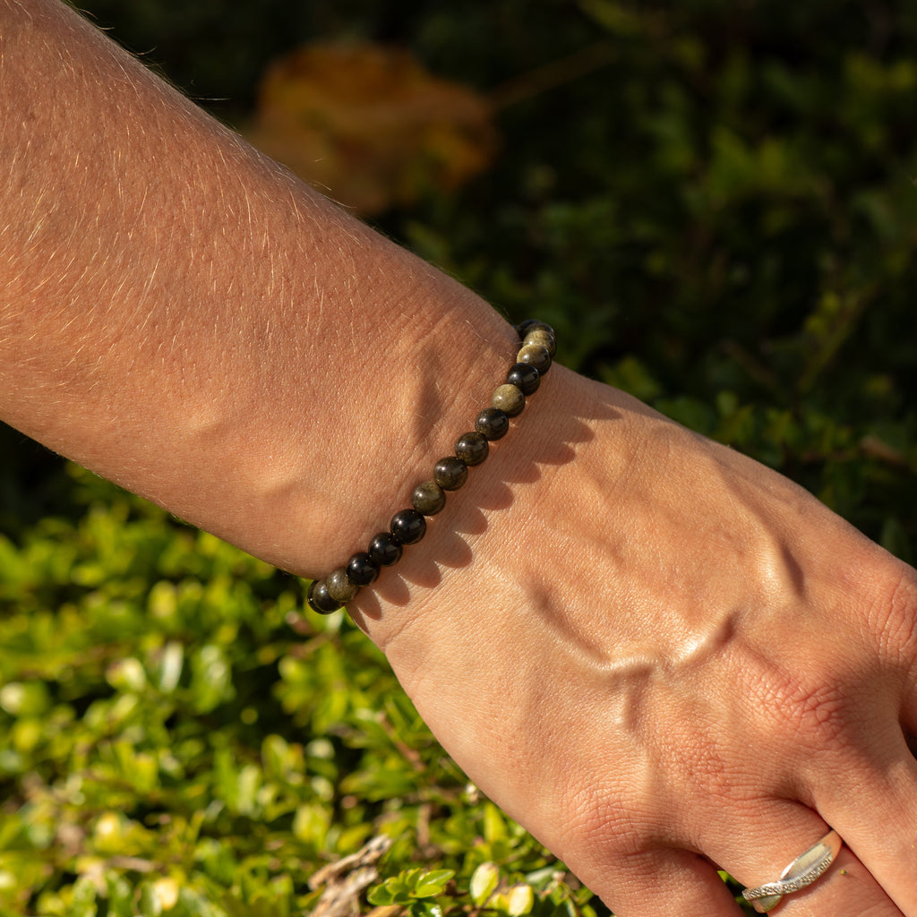 Gold Obsidian bracelet worn outdoors, showing its dark beads