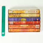 Six HEM incense packs arranged beside the green ashcatcher