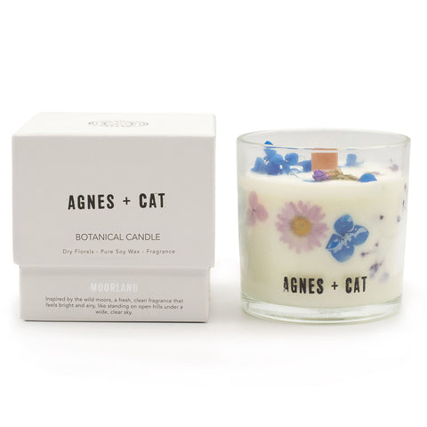 Moorland candle beside its white Agnes + Cat box, showing blue and pink dried flowers