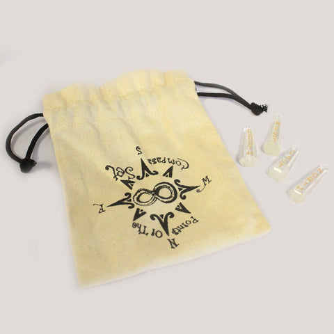 Compass-print pouch beside three of the engraved quartz points