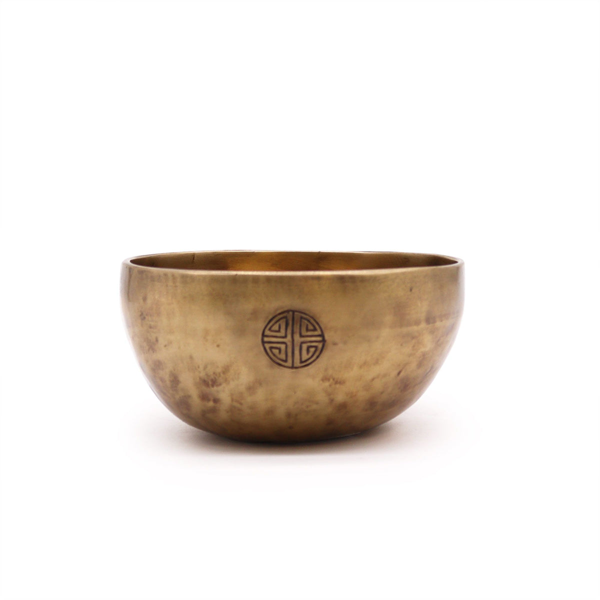 Nepalese moon bowl shown from the front, with a dark circular emblem on its bronze-coloured side