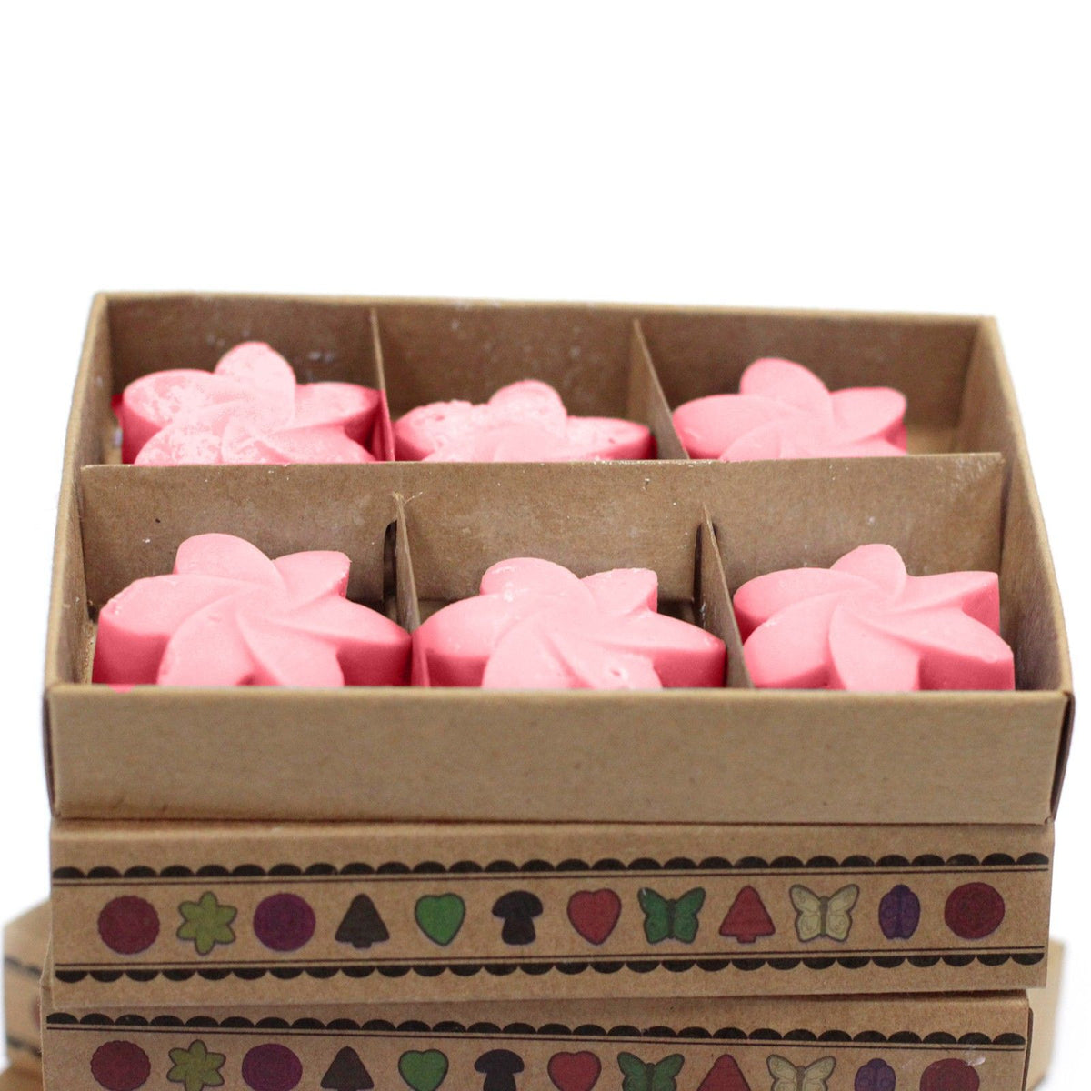 Open divided box showing pink Japanese Magnolia wax melts in close-up, with patterned bands on the box