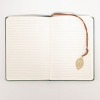 Open notebook showing its pages and leaf-shaped bookmark