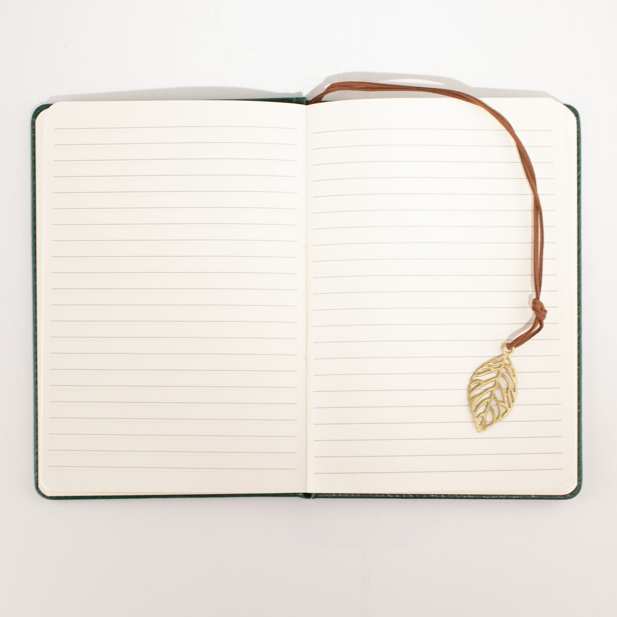 Open notebook showing its pages and leaf-shaped bookmark