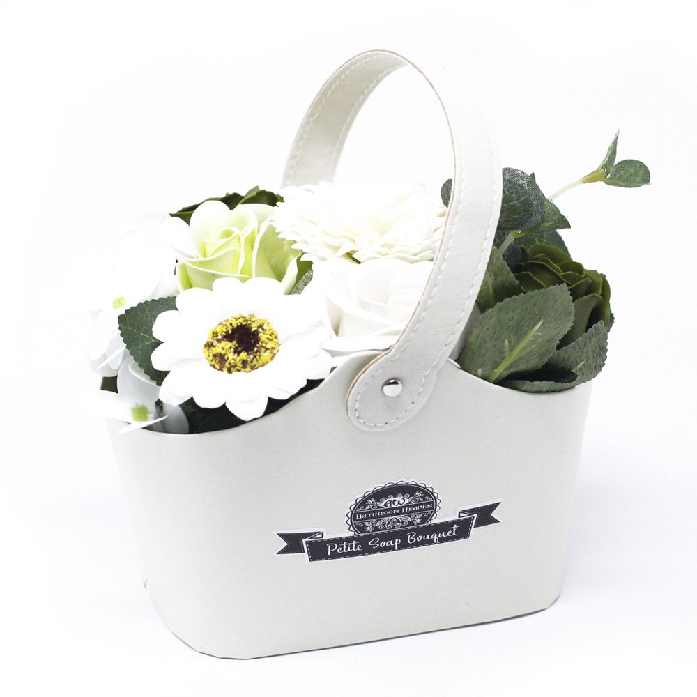 Pastel green soap flower bouquet in a white handled basket, shown alone against a white background