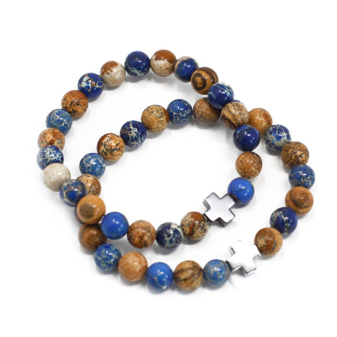 Two blue and brown bead bracelets arranged in overlapping loops on a white background