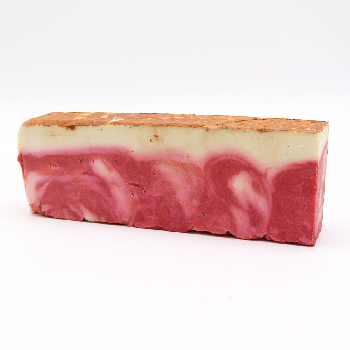 Red clay olive oil soap loaf, a single pink and cream bar shown from the front on white