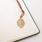 Close-up of a leaf-shaped bookmark on notebook pages
