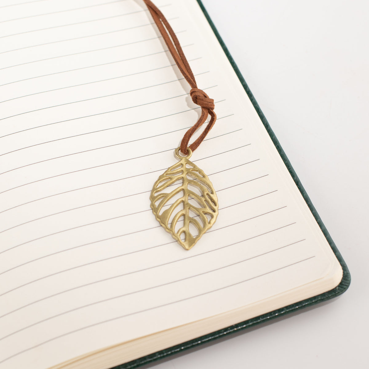 Close-up of a leaf-shaped bookmark on notebook pages