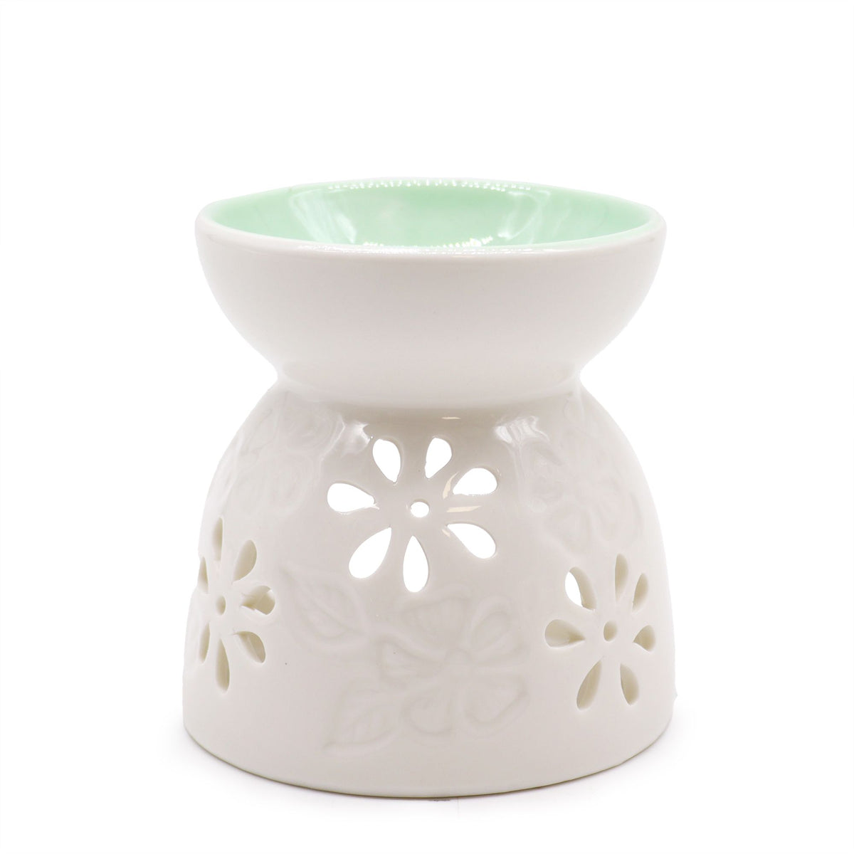 White ceramic oil burner with a floral cut-out design and a pale green bowl top