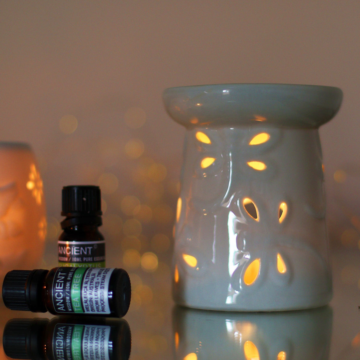 White ceramic oil burner with a dragonfly-style cut-out pattern, unlit