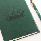 Green notebook cover with a ship illustration