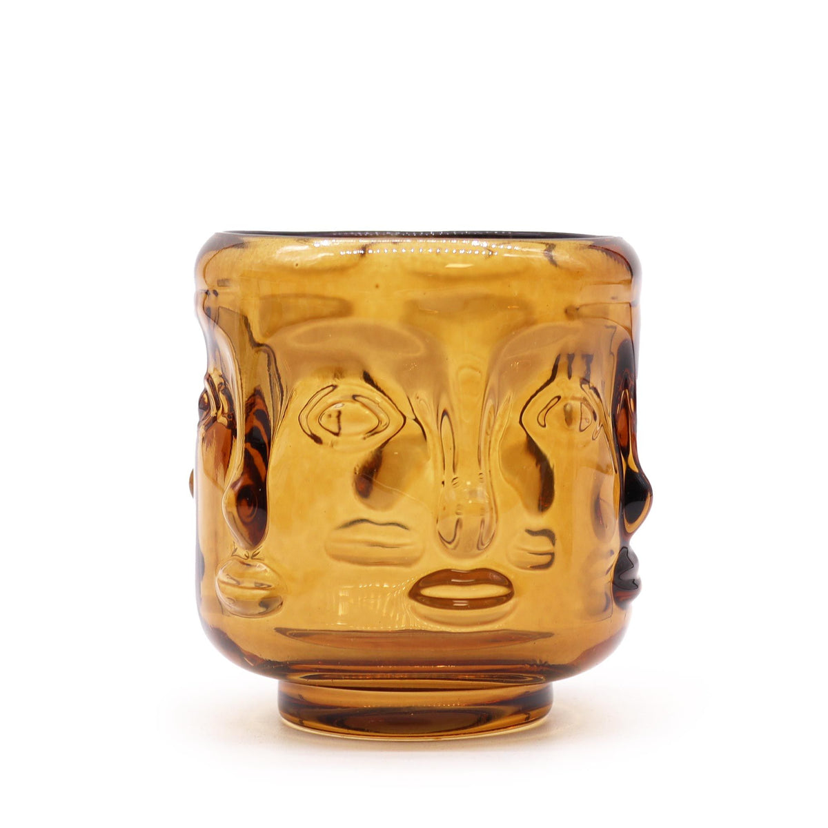 Buddha Faces candle jar in amber glass, shown from the side with raised faces around the outside