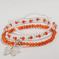 Three beaded bracelets arranged together with a butterfly charm