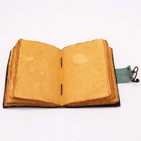 Leather "Moon Phases" Deckle-edge Notebook open to show blank, rough-edged tan pages and side clasp