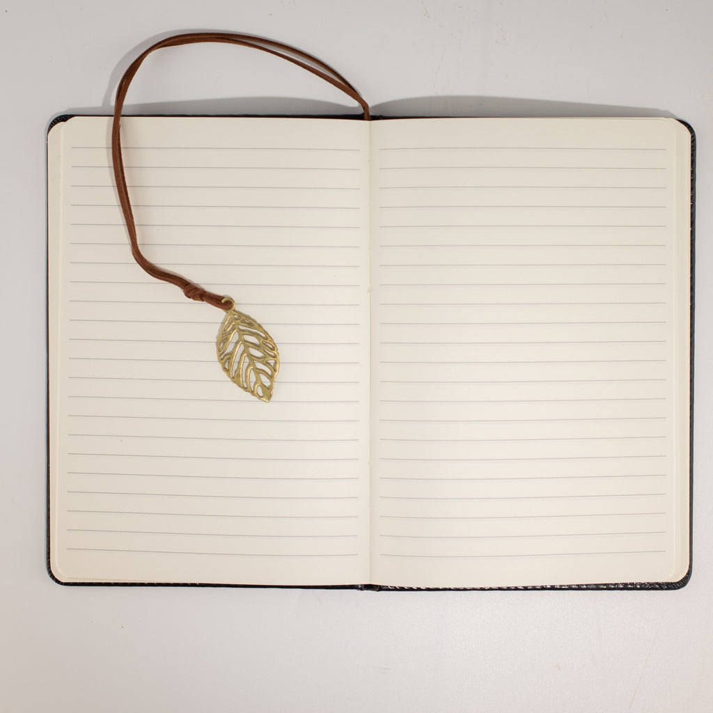 Open notebook showing lined pages and leaf bookmark