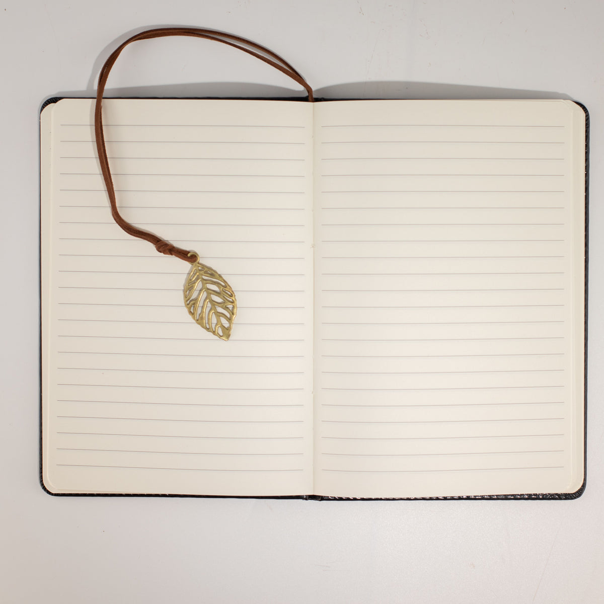 Open notebook showing lined pages and leaf bookmark