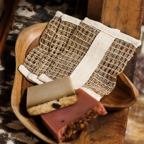 Soft Jute Soap Bag with two bars of soap in a wooden dish, close-up view